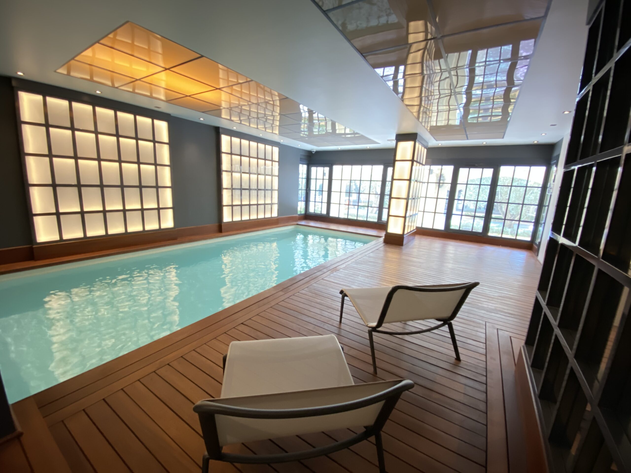 Indoor pool at Cimabue in Monaco with teak decking and backlit glass walls