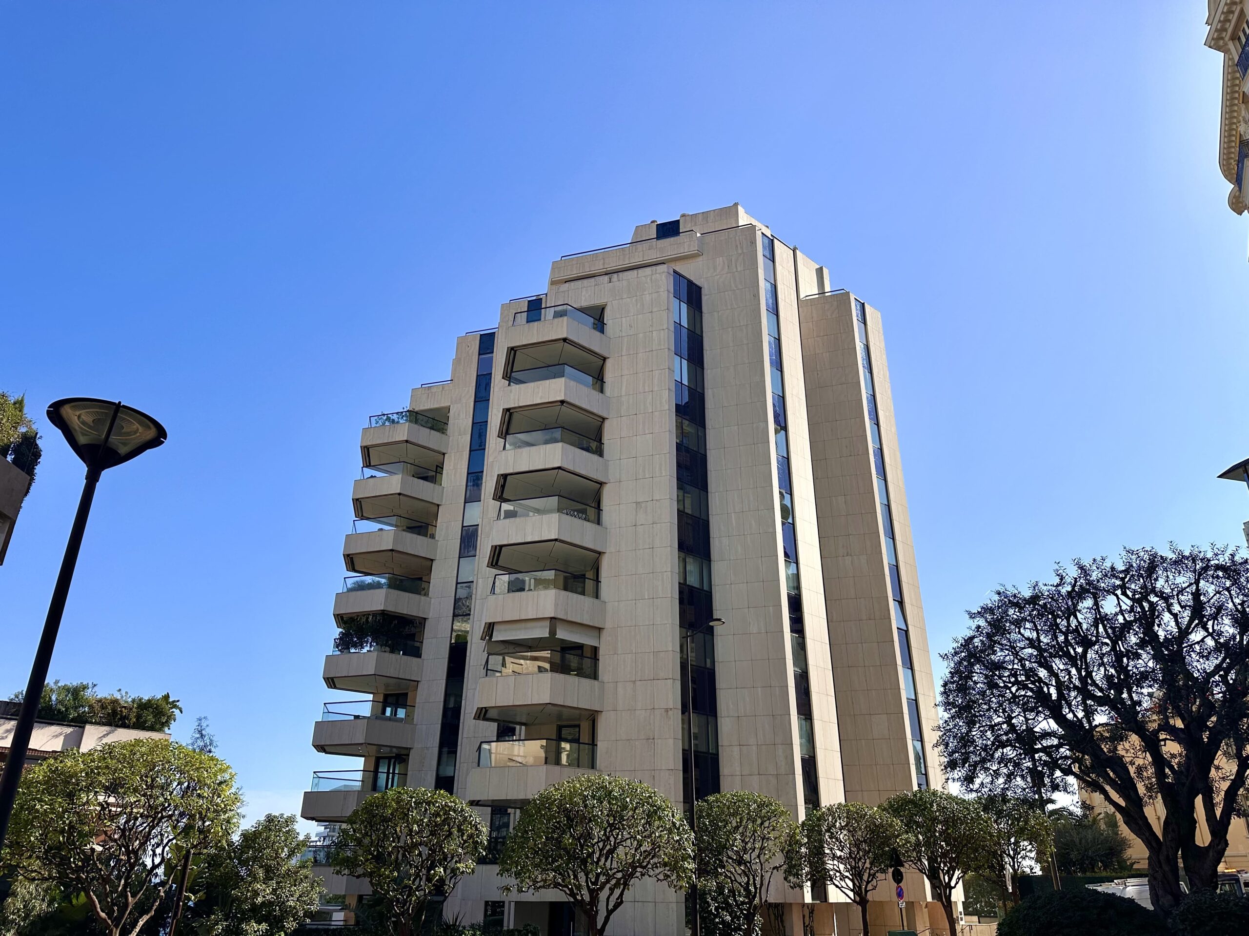 Prince de Galles residential tower with stepped stone facade and large balconies in Monte-Carlo Monaco, apartments for sale and rent in Prince de Galles