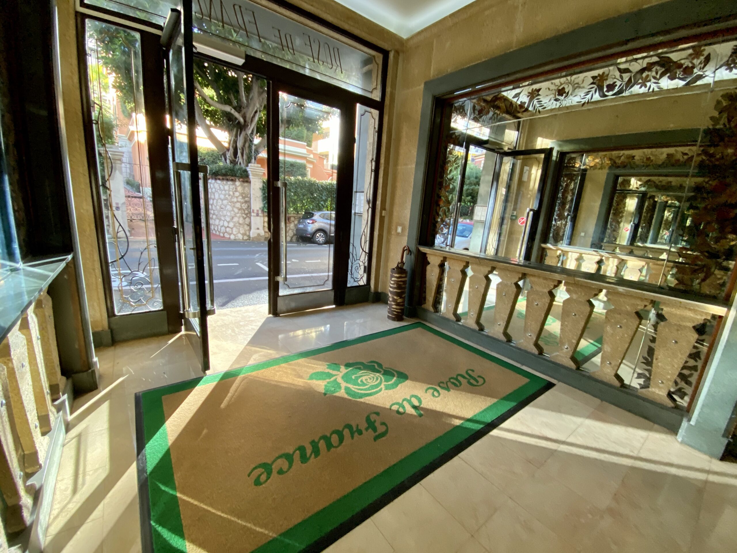 Rose de France lobby entrance with Art Deco stained glass doors and marble flooring, a sought-after Monaco apartment building for buyers and renters
