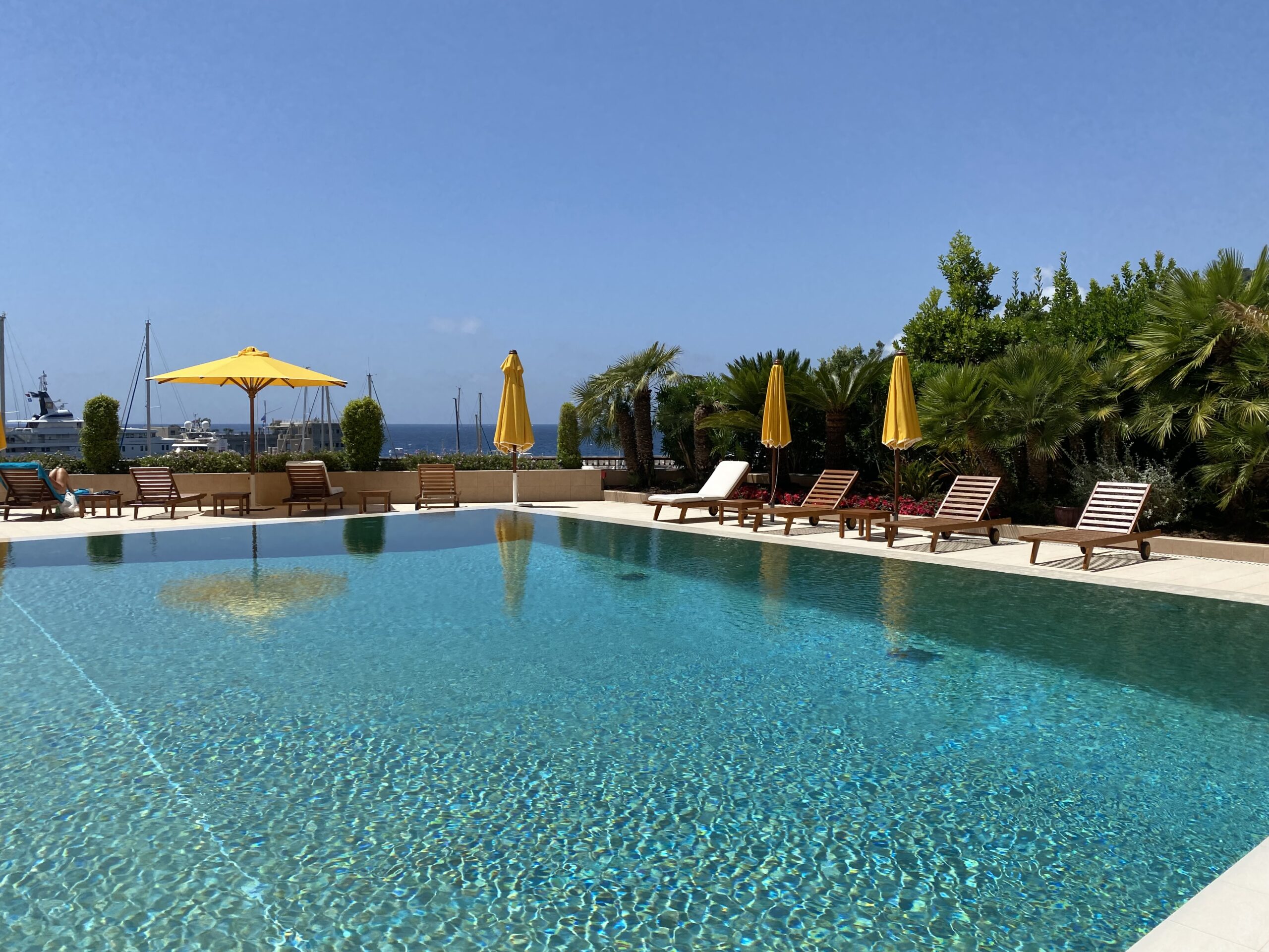 Outdoor pool at Les Terrasses du Port Monaco with sun loungers and port views