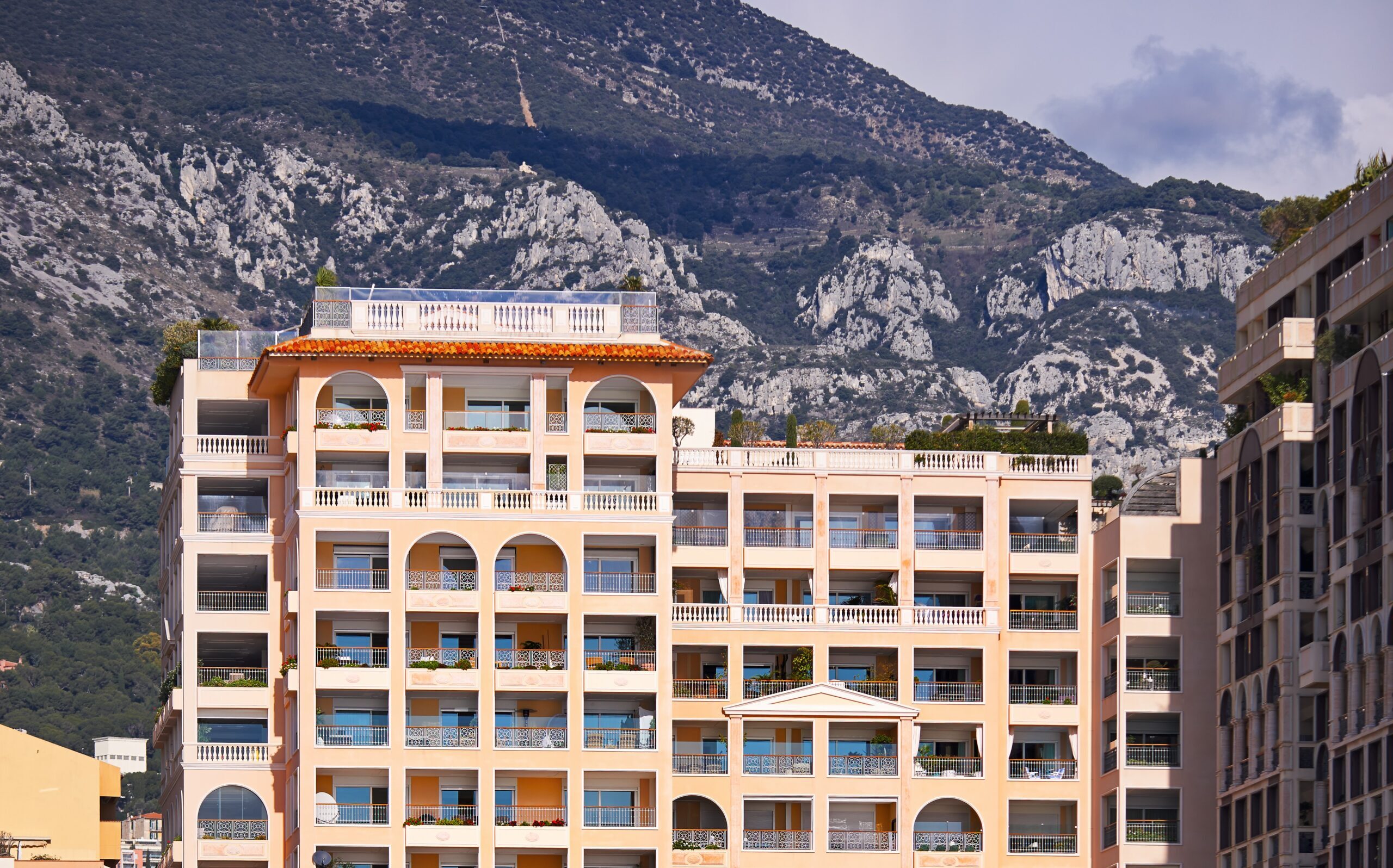 Terrasses du Port building pictured from the outside in Monaco, mountains in the background