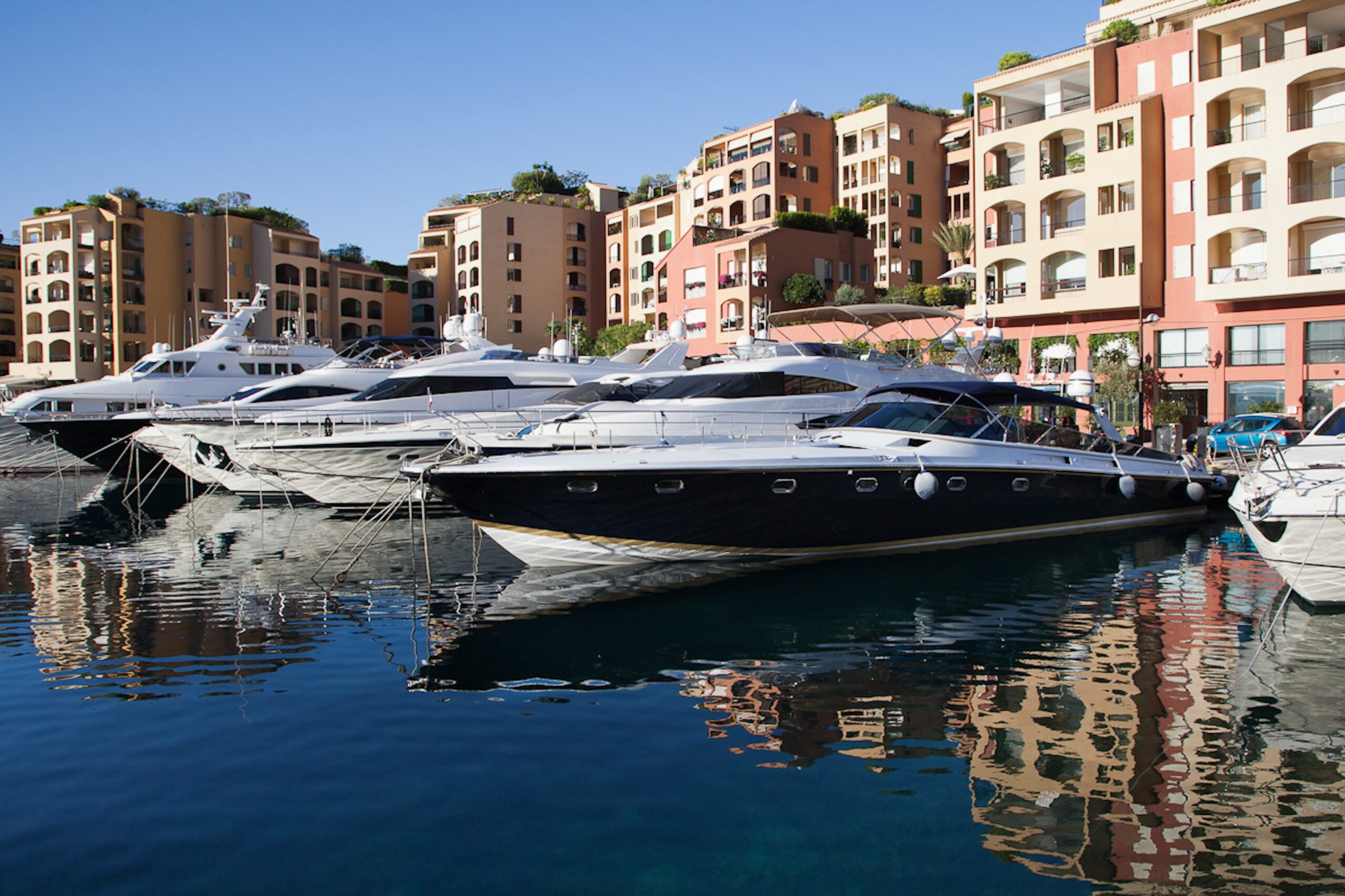 Yachts reflected in the water at Fontvieille port Monaco with Quattrocento visible behind